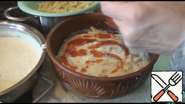Pour half of the Bechamel sauce over the top. Then a little bit of any tomato sauce or ketchup.