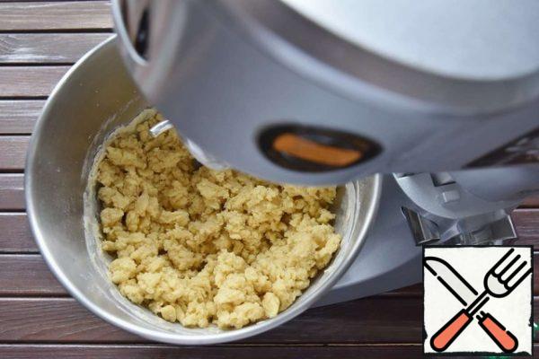 Put the flour, egg yolks, salt, cold butter and water in a container. Begin to knead the dough, grinding it into crumbs.