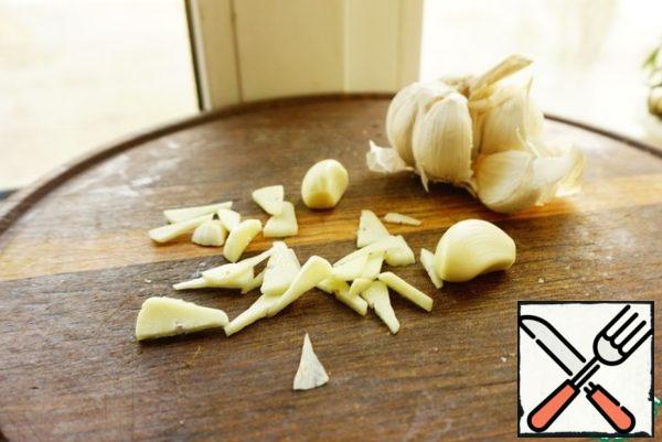 Peel the garlic. Approximately 2-3 cloves are cut into plates.