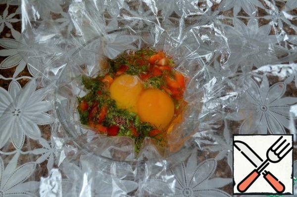 Cut the baking bag into squares, 25*25 cm., grease the middle with vegetable oil. Pour the protein with the vegetables and 2 yolks per serving.