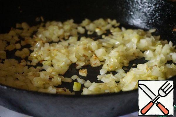 Peel the onion and cut into cubes. Fry it in vegetable oil until golden brown.