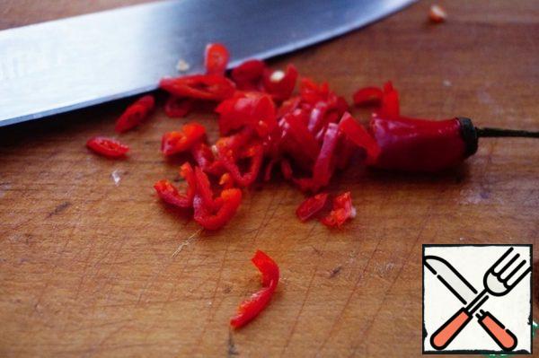 Cut the chili pepper into slices. I do not clean it from seeds and partitions, because I like it sharper. You are guided by your taste. Most of the sharpness is in the seeds and partitions. Add pepper to the sauce.