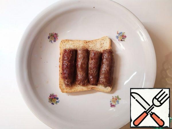 Put the sausages cut lengthwise on the bread.