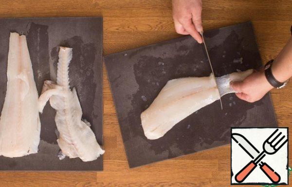 To remove the skin from the fillet, place the knife horizontally between the skin and the meat at the ends of the fillet halves and hold the skin horizontally with one hand. You still have the skin and a piece of the purest fillet. Repeat the operation with the second part.