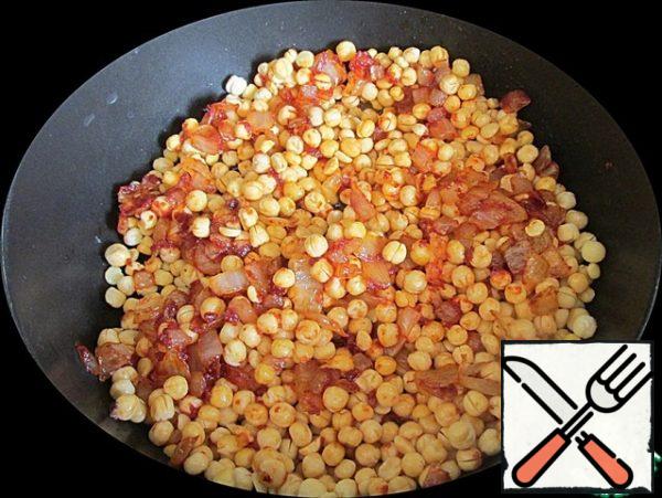 Put the swollen peas in a frying pan. Season with salt and pepper.