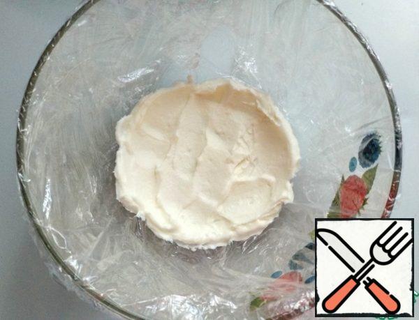 Cover a deep bowl with plastic wrap. Put two full tablespoons of cream.