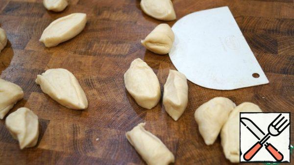 We will knead the finished dough a little, divide it into parts, roll up the sausages and cut them into pieces the size of walnuts.