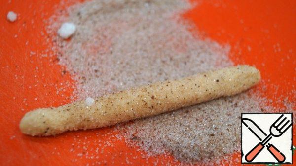 Mix the sugar and cinnamon. Pour on a Board or in a flat plate. Each piece of dough is rolled into a flagellum and rolled several times over a mixture of sugar and cinnamon.