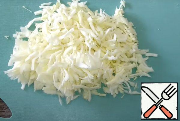 Chop the cabbage into thin strips, put it in a deep bowl.