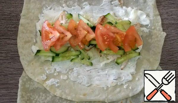 Arrange the cabbage, chicken, cucumbers and tomatoes in layers. Top with a little more sauce;