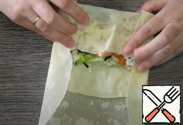 Tightly roll the pita bread with the filling in the form of an envelope;