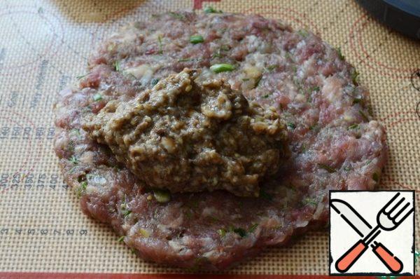 Turn on the oven to warm it up.
Divide the minced meat into 5 equal parts, roll each into a circle with a diameter of 12 cm..
Put 1.5 tablespoons of filling on the half.