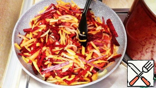 Pour a little sunflower oil into the pan and start frying the onion, after 3 minutes add the carrots, and after another 3 minutes add the bell pepper and beetroot. Cook for 5 minutes until the vegetables are lightly browned. You don't need to fry them too hard.