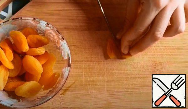 Wash dried apricots, dry them.