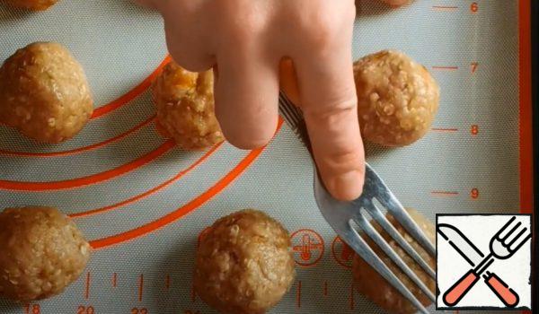 Form small balls from the dough, put them on a baking sheet and press them across with a fork.