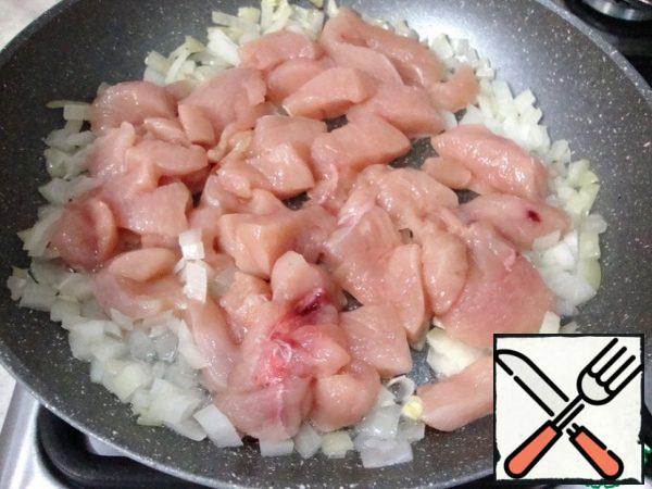 Add the chicken breast to the onion and fry until the meat turns white.