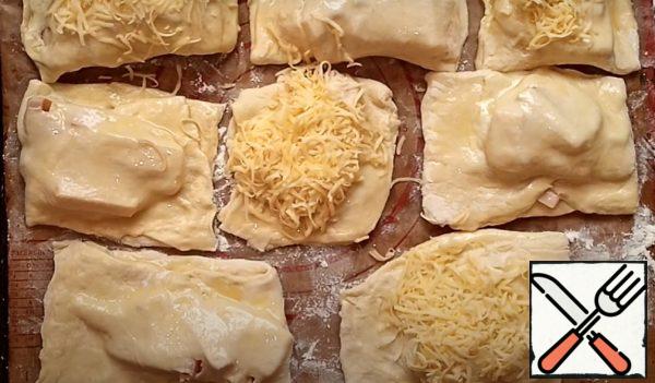 Brush the puffs with beaten chicken egg and sprinkle some of them with grated cheese. Let it come up a little and send it to the oven at a temperature of 180 C for 20-25 minutes.