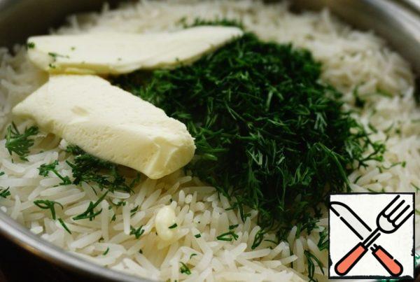 Remove the garlic from the boiled rice and add the dill and butter to the pan. Cover with a lid for just a minute so that the oil begins to melt.