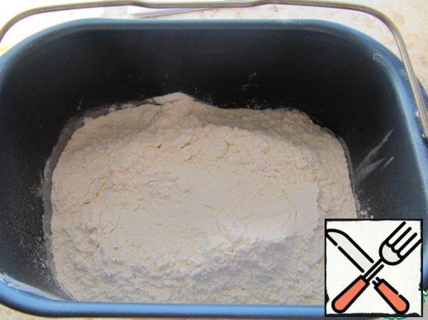 Pour the sifted flour, the remaining 110 g of sugar, salt, vanilla sugar and mix into a bread maker bucket.
Put the pieces of butter in the flour, mix and make a hollow in the flour with a spoon.
Pour the prepared yeast mixture into it, do not mix. Place the bucket in the bread maker.
At a temperature of about 20C, the starter can ripen for about 8-10 hours, at a higher temperature this time can be reduced to 6 hours. In my case, the bread maker stood on the loggia from 10 pm to 6 am, then set the "Dough" mode.