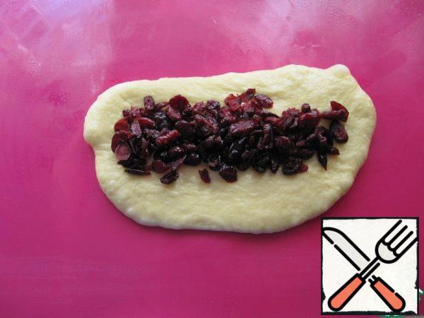 Then lay out the filling of dried cherries, fix the edges tightly.