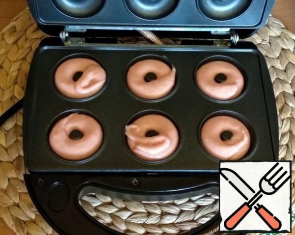 Insert the donut molds into the slow cooker. Turn on the slow cooker, when the green indicator lights up, you can start cooking. Fill the bottom cells with dough, for this I used a pastry bag.