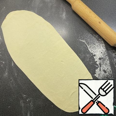 In Turkey, this process is done by hand, the dough is stretched into the same long tortillas. I do not know how to do this, so the dough is rolled out with a rolling pin in a layer, 40 cm long, 15-20 cm wide. (the length is adjustable according to the size of Your baking sheet).