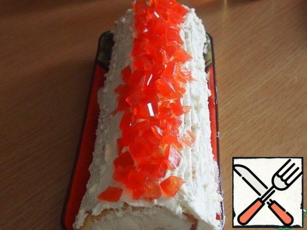 Spread the remaining cream on top of the roll and decorate with a crown of jelly pieces.