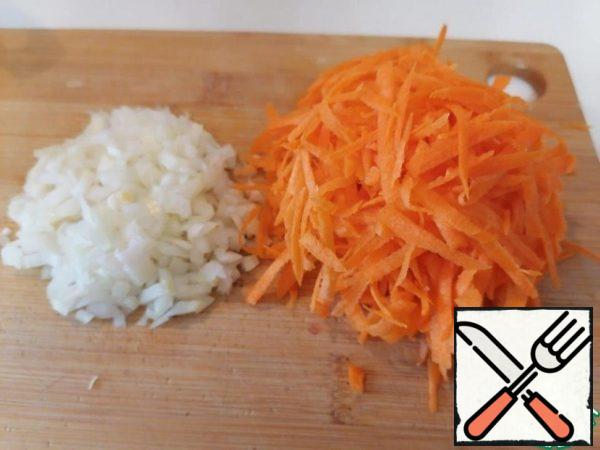 Start cooking the roast. Cut the onion into small cubes, grate the carrots on a coarse grater.