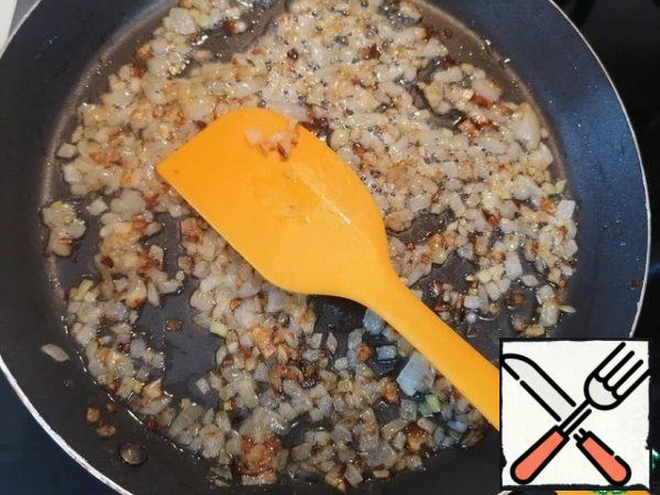 Pour 1 teaspoon of oil into a frying pan and put the onion, fry until golden brown.