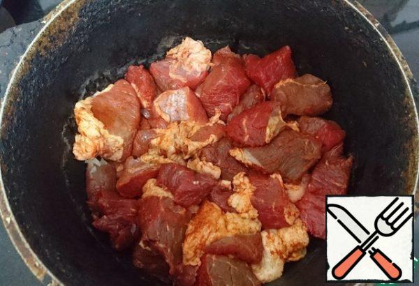 Put the meat on top of the onion, without stirring. Cover with a lid. Let it boil, turn down the heat (do not stir)