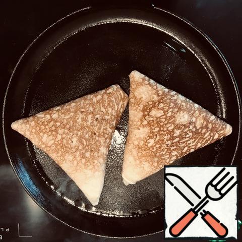 Grease the pan with fat and put the triangles with the seams down. Fry for a minute.