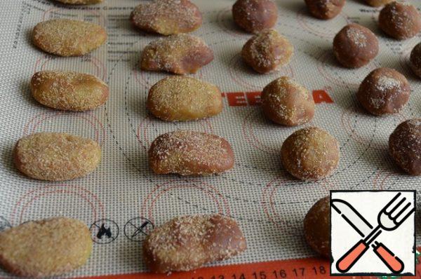 Turn on the oven to warm it up. We form cookies.
Divide one part of the dough into pieces (the size of a walnut),
roll out in the form of buns and ovals, roll in a mixture of sugar and cinnamon.
Place on baking paper and on a baking sheet.
