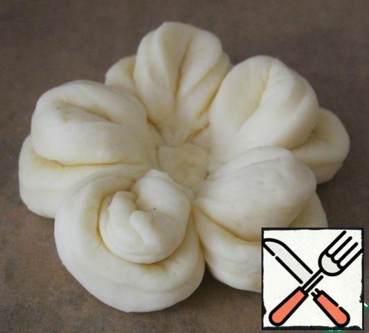 Do the rest of the petals and spread them out forming a flower.
In the middle of a small piece of dough, slightly pressing.
This is how we make all the buns.
In the middle, spread the jam.
Cover and leave in a warm place for 30 minutes.
