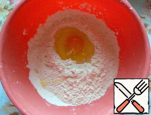 Sift the flour into a bowl, add salt, and beat in the egg.