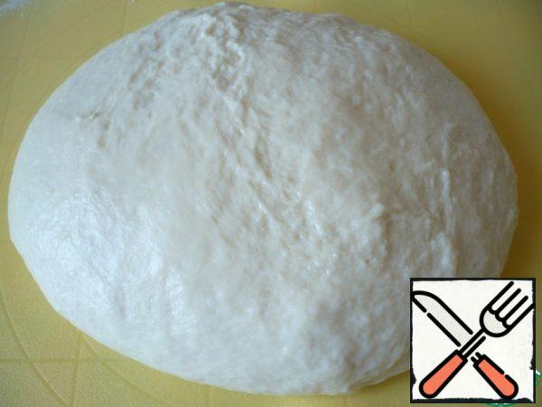 The surface of the top, lightly sprinkle with flour. Spread the dough and knead it a little more with your hands.