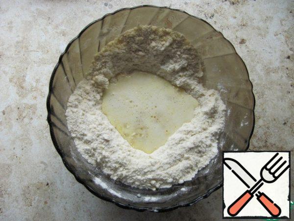 To prepare the dough, sift wheat flour with baking powder and mix. RUB the cold butter into a crumble with flour. Beat the egg with a whisk with sugar and milk. Combine the liquid and dry ingredients, quickly knead the dough, cover with cling film, and send it to the refrigerator for 20-30 minutes.
