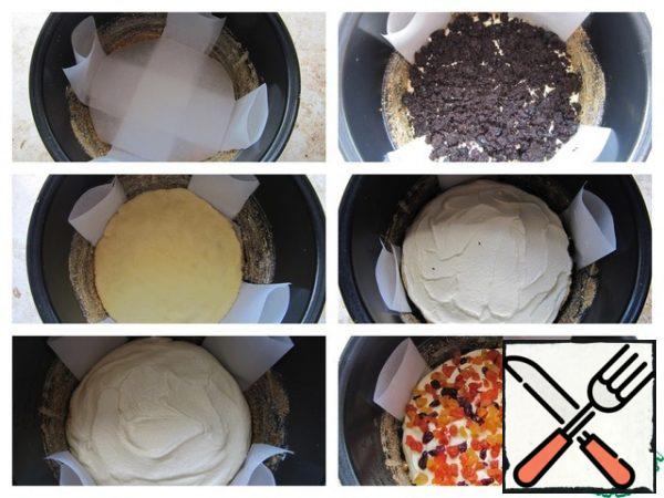 The bowl of a slow cooker is greased with butter, sprinkle with sweet breadcrumbs. At the bottom of the form, put double strips of baking paper crosswise. Put a layer of dough on the bottom, then half of the curd filling, a layer of poppy-prunes filling. Then lay out the second layer of dough, on it the remaining half of the curd filling, a layer of filling from dried apricots and dried cherries.