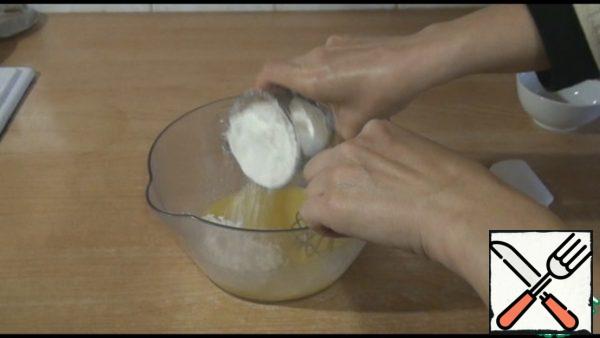 For the dough, mix the egg with sugar, add melted butter. Add gradually the flour and baking powder, stir first with a whisk, then with a spoon.
