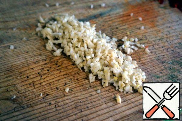 Crush the garlic and chop it very finely with a knife.