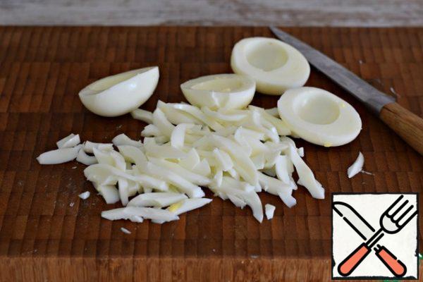 Hard-boiled eggs. Separate the whites from the yolks. Cut the whites into strips.