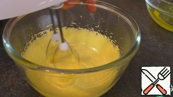 Add 1 tablespoon of sugar to the yolks and beat with a mixer until they double in volume and lighten. Then add vanilla sugar and, continuing to beat in small portions, pour in vegetable oil in a thin stream. After the butter, add the sifted flour. And mix in small portions, then add milk, without stopping whipping.