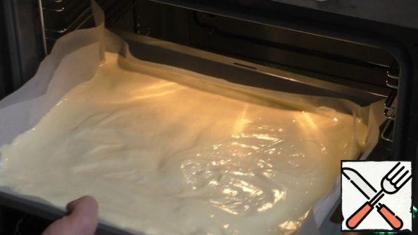 After all the proteins are added, the dough is spread on a baking sheet covered with parchment paper. The dough is leveled over the entire surface of the baking sheet. Put in a preheated oven to 180°With in 20 min.