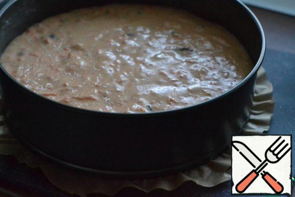 Drain the water from the raisins. Chop the nuts finely with a knife.
Add to the dough. Mix everything well and pour the dough into the prepared mold (24 cm).