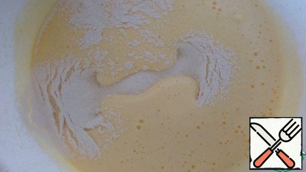 Sift the flour with baking powder and add it to the eggs in 3 steps. Stir with a spatula.