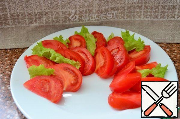 Wash tomatoes and greens and dry them. Cut the tomato into slices.
Place on a serving platter, sprinkled with lettuce leaves.