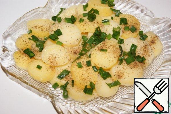 Boil the potatoes the day before. It is advisable to choose small and homogeneous tubers.
Cut the peeled potatoes into washers, put them on a platter, season with salt and pepper. Sprinkle 1/3 of the onion.