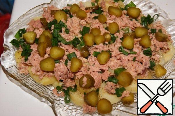 Remove the fish from the oil or its own juice. Put it on top of the potatoes.
Sprinkle half of the onion and cucumbers again.
If you don't like tuna, you can safely use your favorite canned or even smoked fish. It goes well with salmon, beluga, saury, trout... It is wonderfully combined with sturgeon, but still more dietetic with tuna.