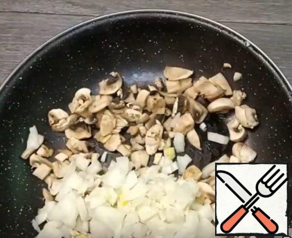 Cut the mushrooms into cubes, evaporate the liquid in a dry pan, add diced onions, and grow. oil and fry until ready.