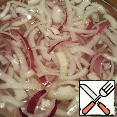 Put the sliced onions in a suitable container, take them apart with your hands or fork and pour boiling water over them. Wait 1-2 minutes and flip the onion into a colander. Allow the water to drain completely.