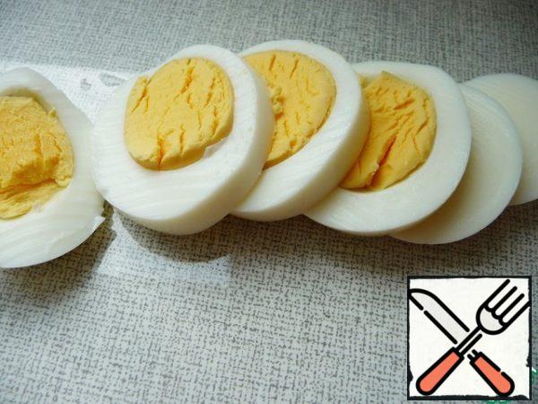 Hard-boiled egg. Peel and cut into circles or slices.